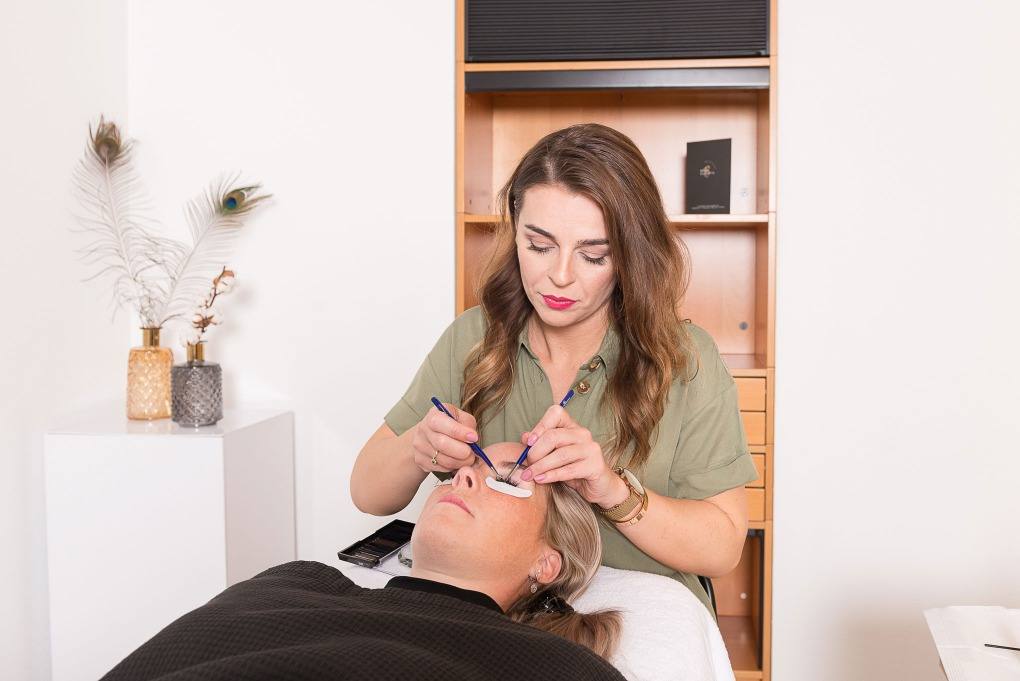 Klaudija zet wimperextensions bij een klant in de salon